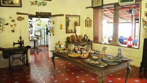 A room with a wooden table displaying various ceramic items.