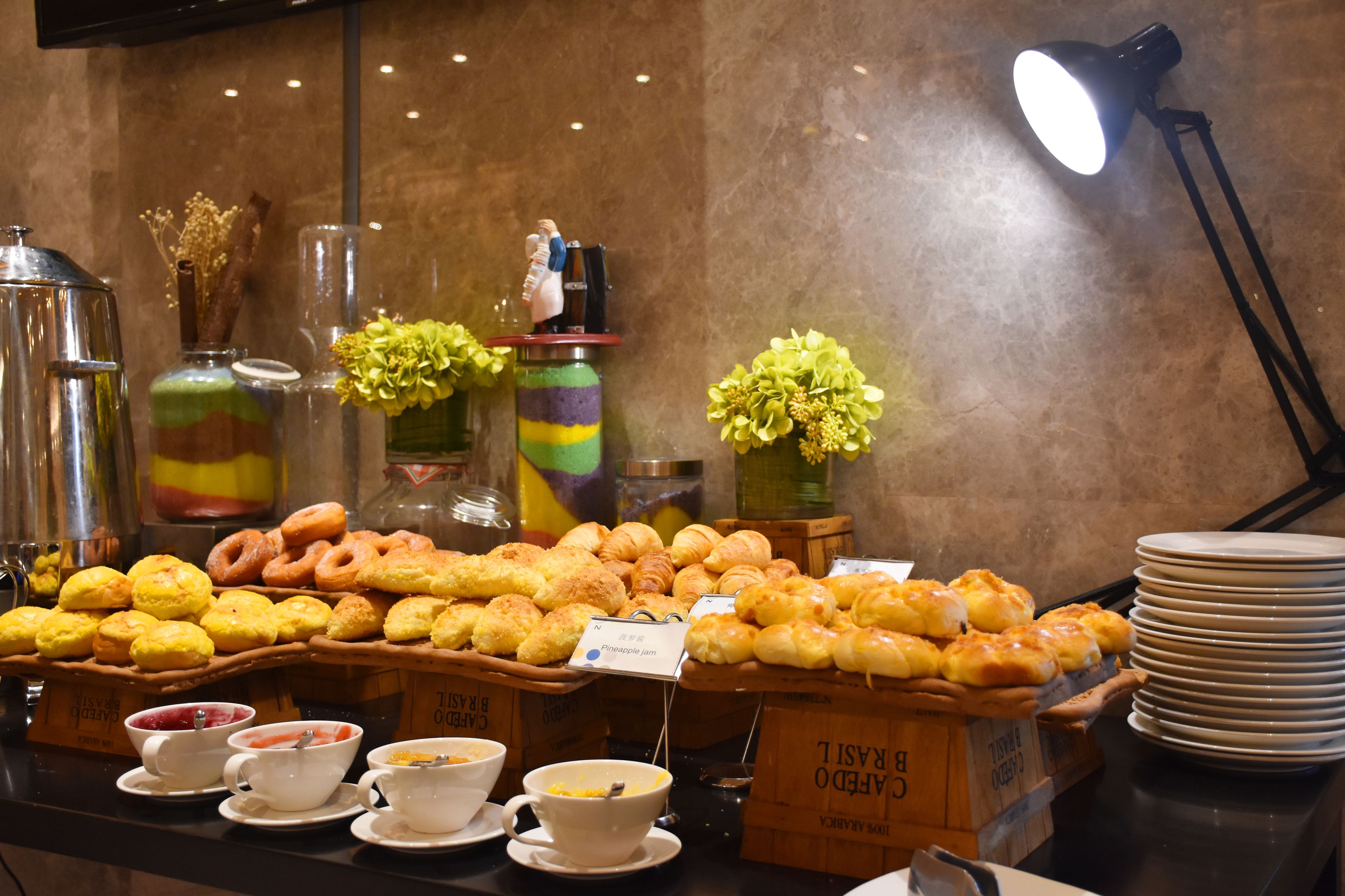A buffet with various pastries, coffee, and tea options.
