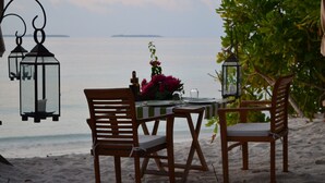 Una mesa de madera preparada para dos, con vista al mar.