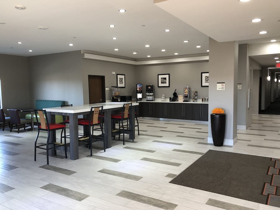 Un hall d’hôtel moderne doté d’un bar, de coins salon et d’un comptoir d’accueil.