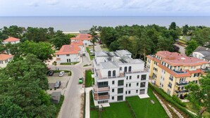 Un quartier résidentiel avec des maisons modernes, une route et une plage en arrière-plan.