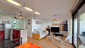 Eine moderne Wohnung mit Küche, Essbereich, Wohnzimmer und einem Balkon.