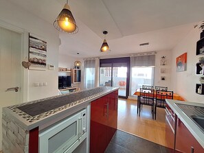A modern kitchen with a central island, pendant lighting, and a dining area with a table and chairs. - AL 133 - Apartment with WiFi and parking in Vera Playa (Vera playa)