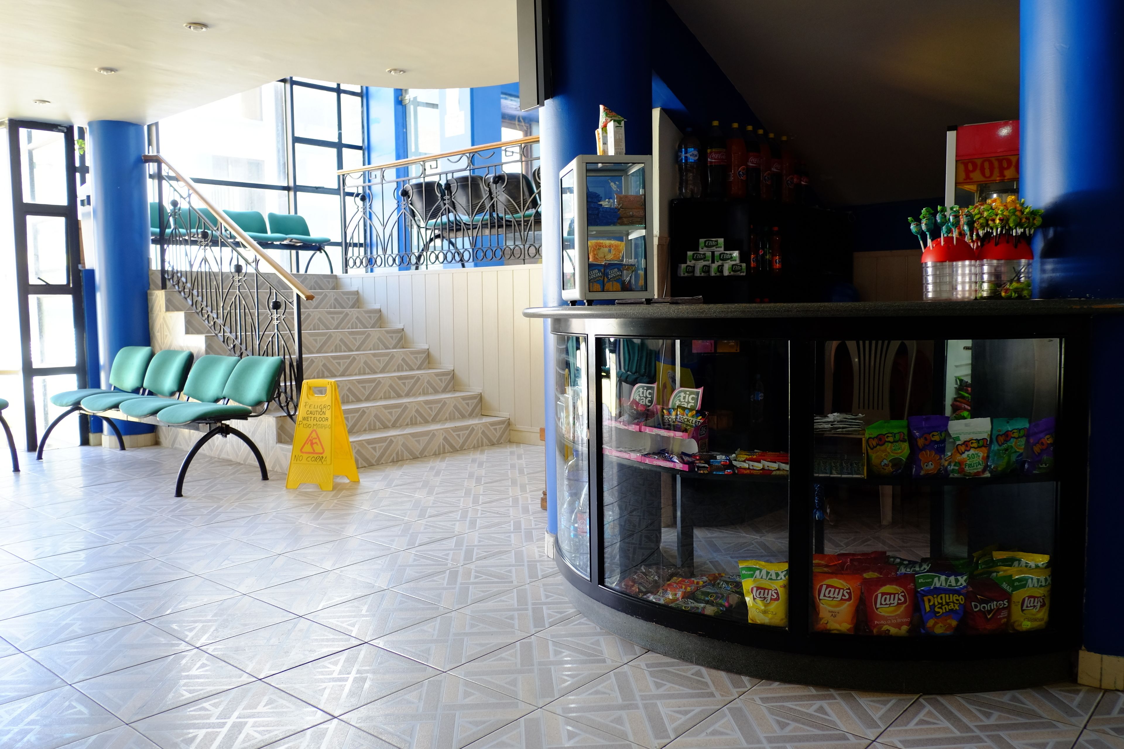 A lobby with a seating area, a snack bar, and a staircase.