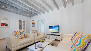 Ein modernes Wohnzimmer mit einem weißen Sofa, einem Couchtisch und einem Fernseher.
