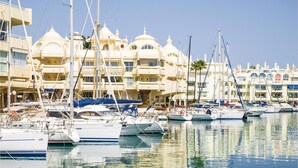 Un puerto deportivo con varias embarcaciones amarradas, rodeado de edificios de varios pisos con detalles arquitectónicos en forma de cúpulas.