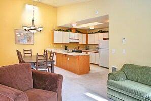 A compact living space with a kitchen island, dining area, and seating. - Alpine Villagers (Leavenworth)