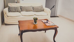 A living room with a wooden coffee table, a vase with flowers, and a magazine. - Il Gattopardo (Florence)