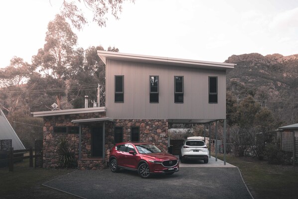 Una casa moderna de dos pisos con base de piedra y techo plano.