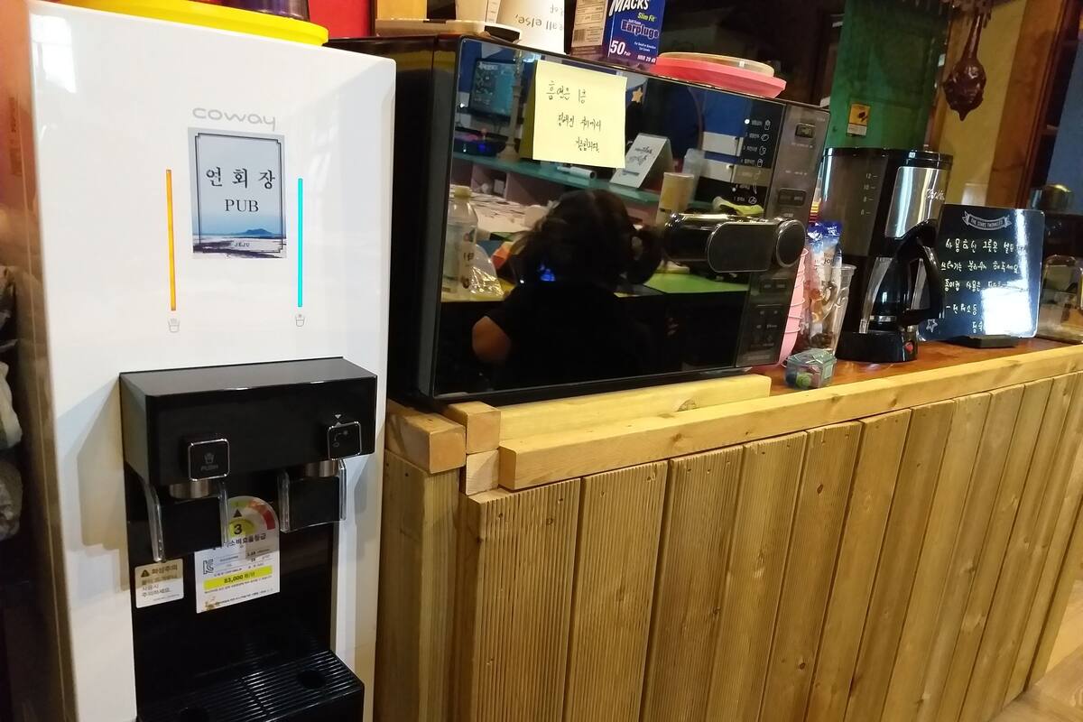 A coffee machine, a refrigerator, and a counter with a wooden partition.