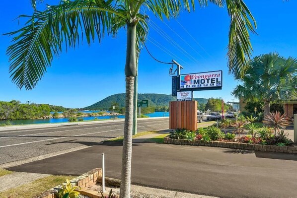 Un motel avec une enseigne, des palmiers et une route en arrière-plan.