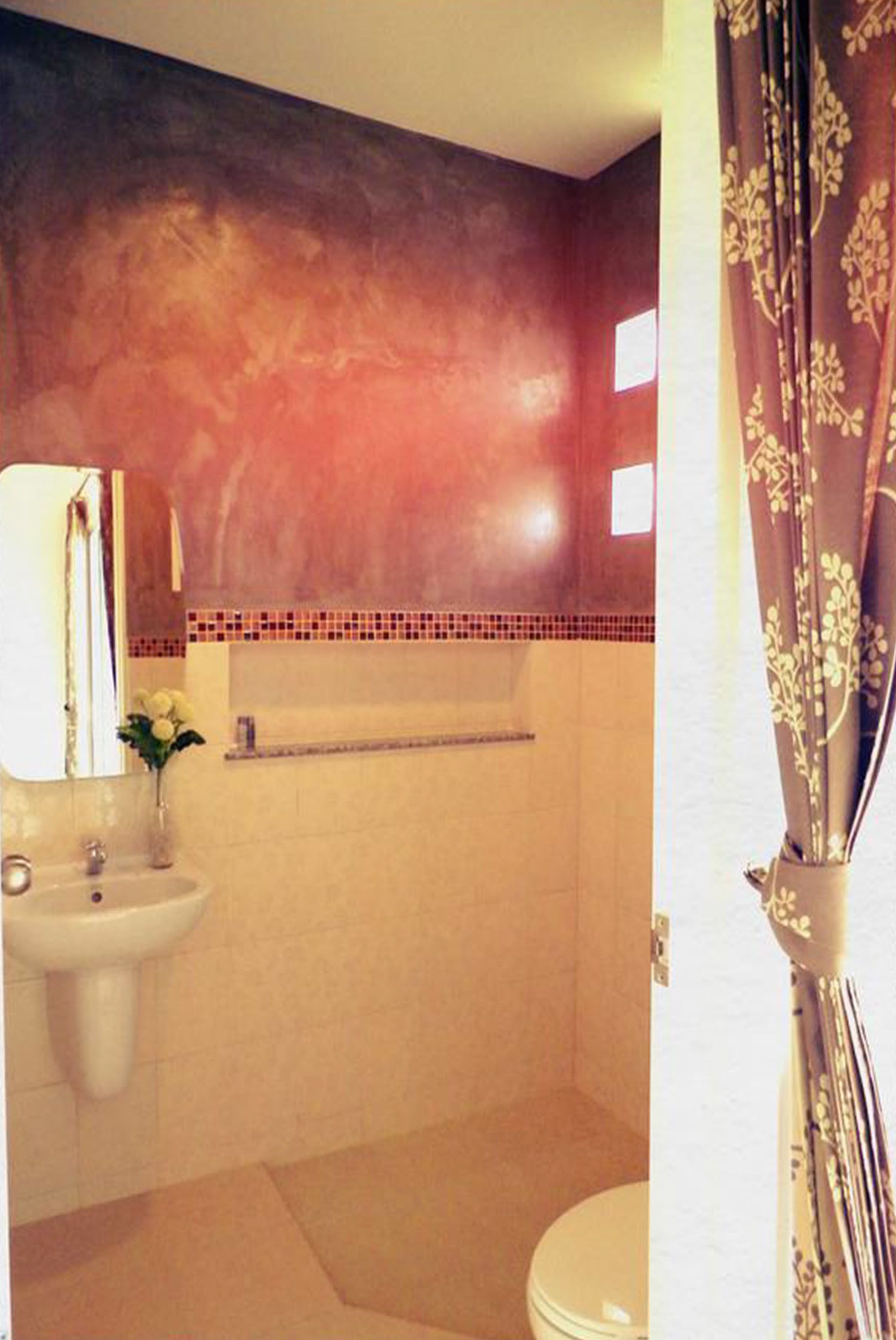 A bathroom with a sink, mirror, and toilet.