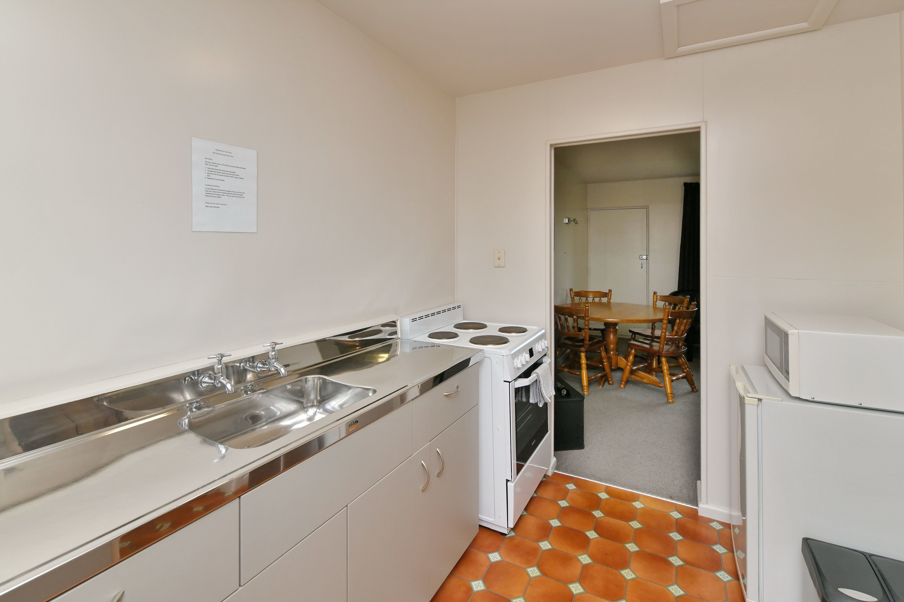 A compact kitchen with a stove, sink, and refrigerator.