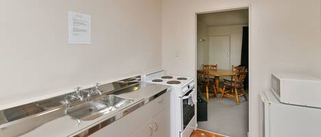 A compact kitchen with a stove, sink, and refrigerator.