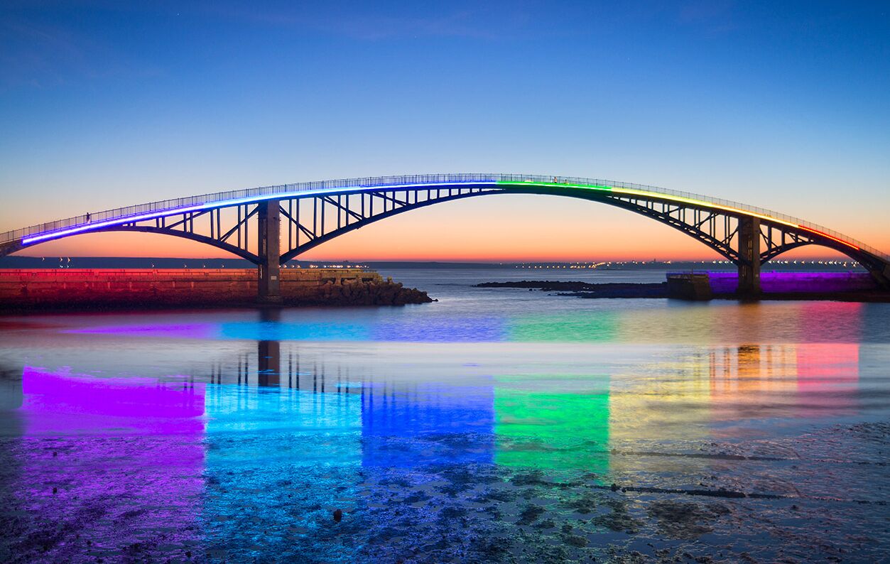 A bridge with a clear view of its structure and the calm water below.