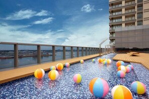 Una piscina al aire libre, sombrillas, sillones reclinables de piscina