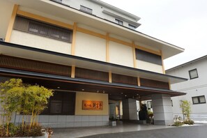 A modern building with a flat roof, large windows, and a covered entrance area. - Shintomi-tei (Matsushima)