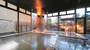 A hot spring bath area with a view of the outdoors, wooden benches, and a stone pillar. - Shintomi-tei (Matsushima)