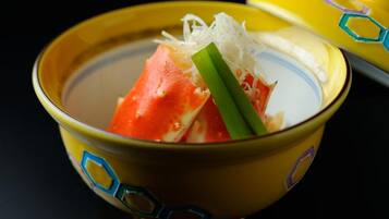 A bowl of soup with a piece of salmon and green onions.