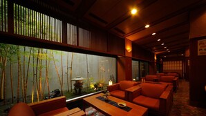 A traditional Japanese-style room with tatami flooring, low wooden tables, and red cushioned seating. - Shintomi-tei (Matsushima)