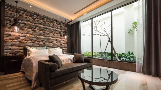 A modern bedroom with a bed, a sofa, and a glass coffee table. - Green Palm (Yuanlin)