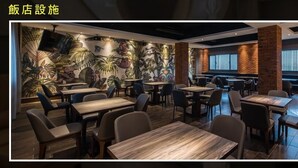 A restaurant interior with wooden tables and chairs, brick walls, and a mural of tropical plants. - Green Palm (Yuanlin)