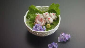A bowl with food and flowers on a dark surface.