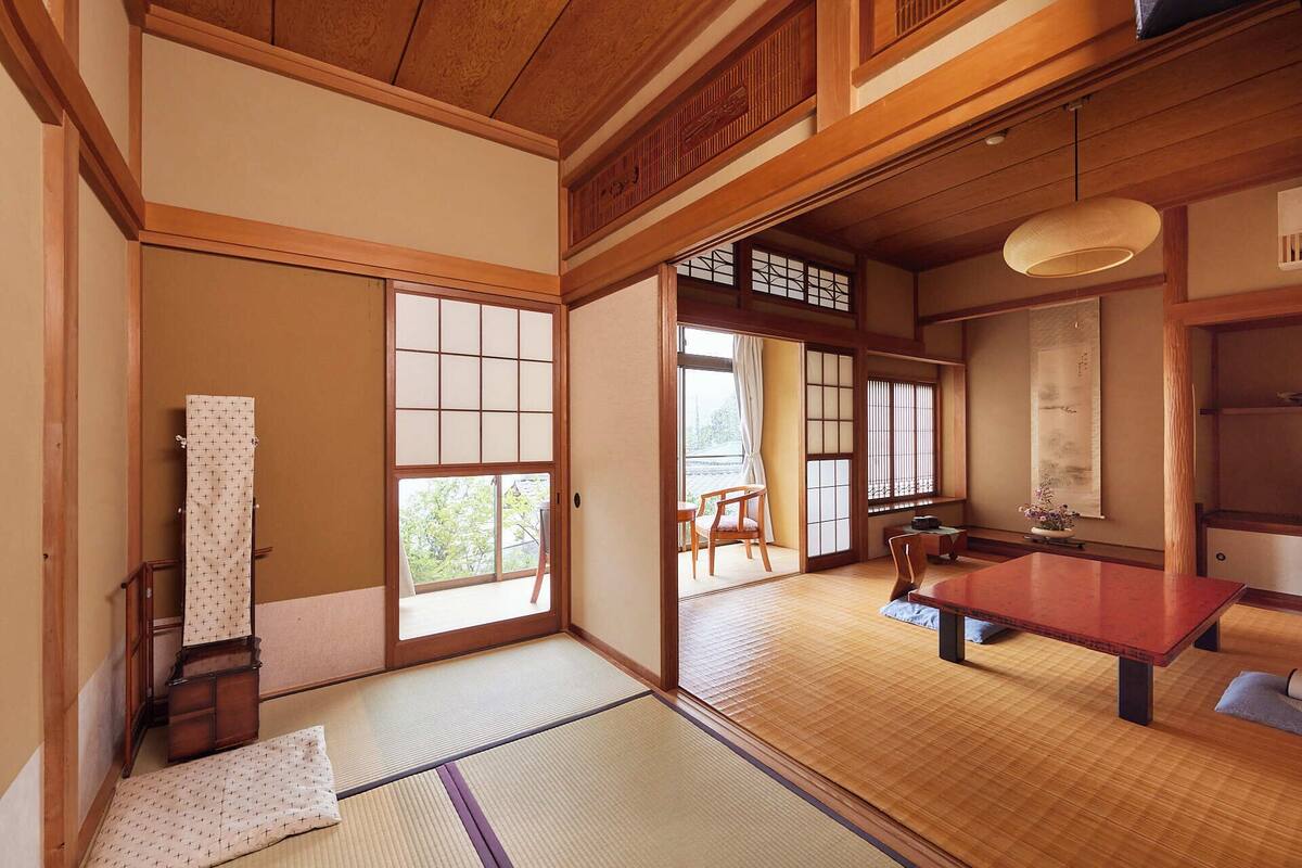A traditional Japanese room with tatami flooring, sliding doors, and a low wooden table.