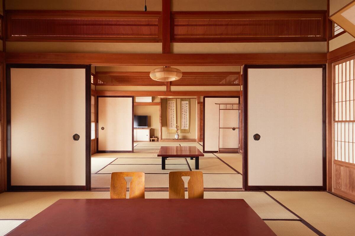 A traditional Japanese room with tatami flooring, a low table, and sliding doors.