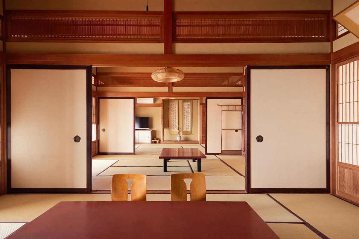 A traditional Japanese room with tatami flooring, a low table, and sliding doors.
