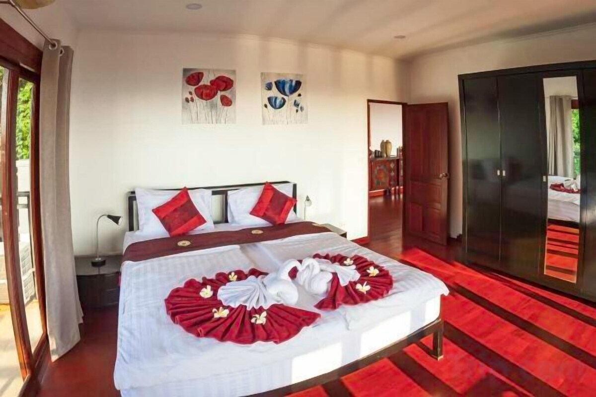 A hotel room with a bed, a wardrobe, and a door leading to a balcony.