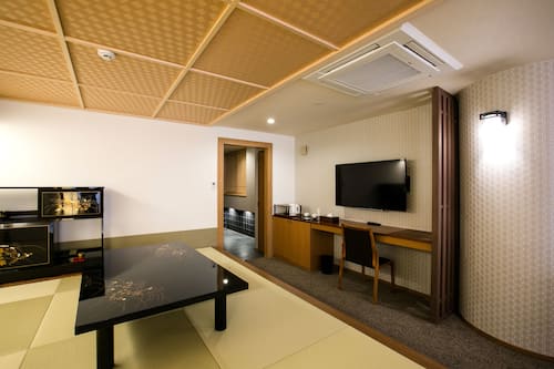 Habitación cuádruple de diseñador | Área de sala de estar | Televisión de pantalla plana de 47 pulgadas con canales por cable