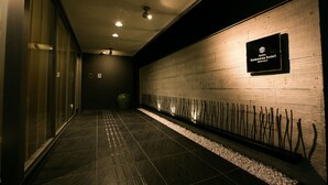 A hallway with a wooden wall and a sign for the Kyoto Kamiza Hotel.