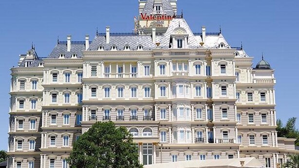 A large, multi-story building with a prominent 'Valentina' sign on the roof.