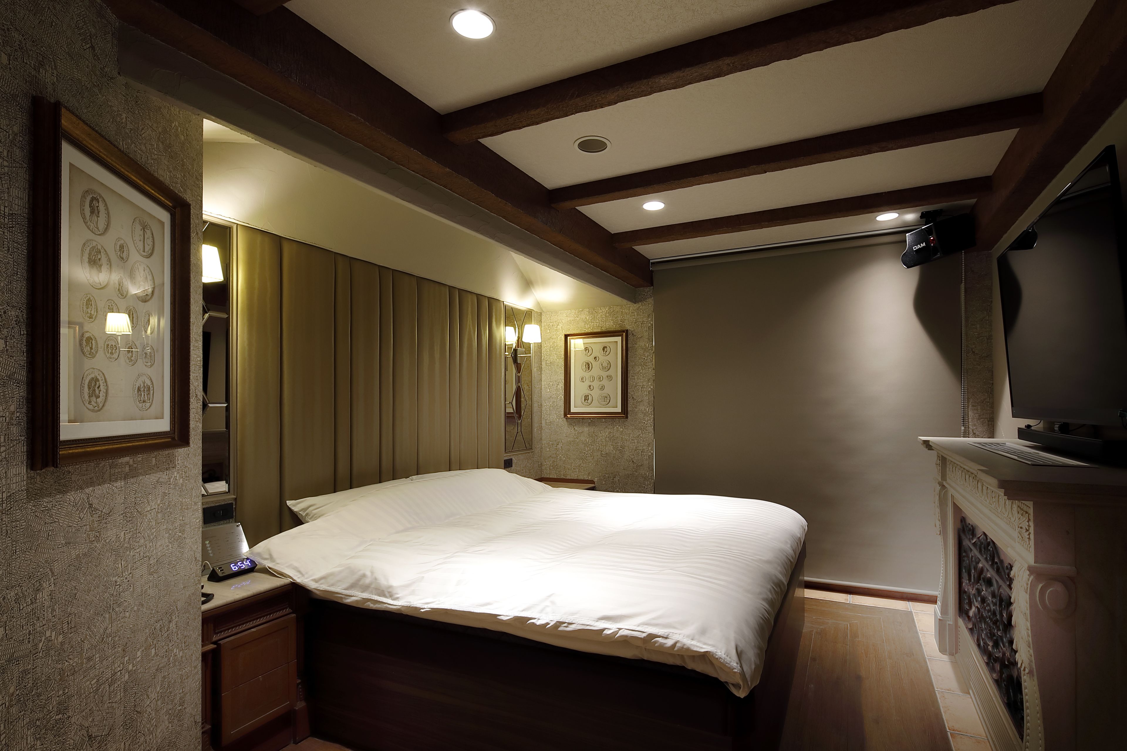 Ein Hotelzimmer mit einem großen Bett, einem Schreibtisch mit Lampe und einem Fernseher.
