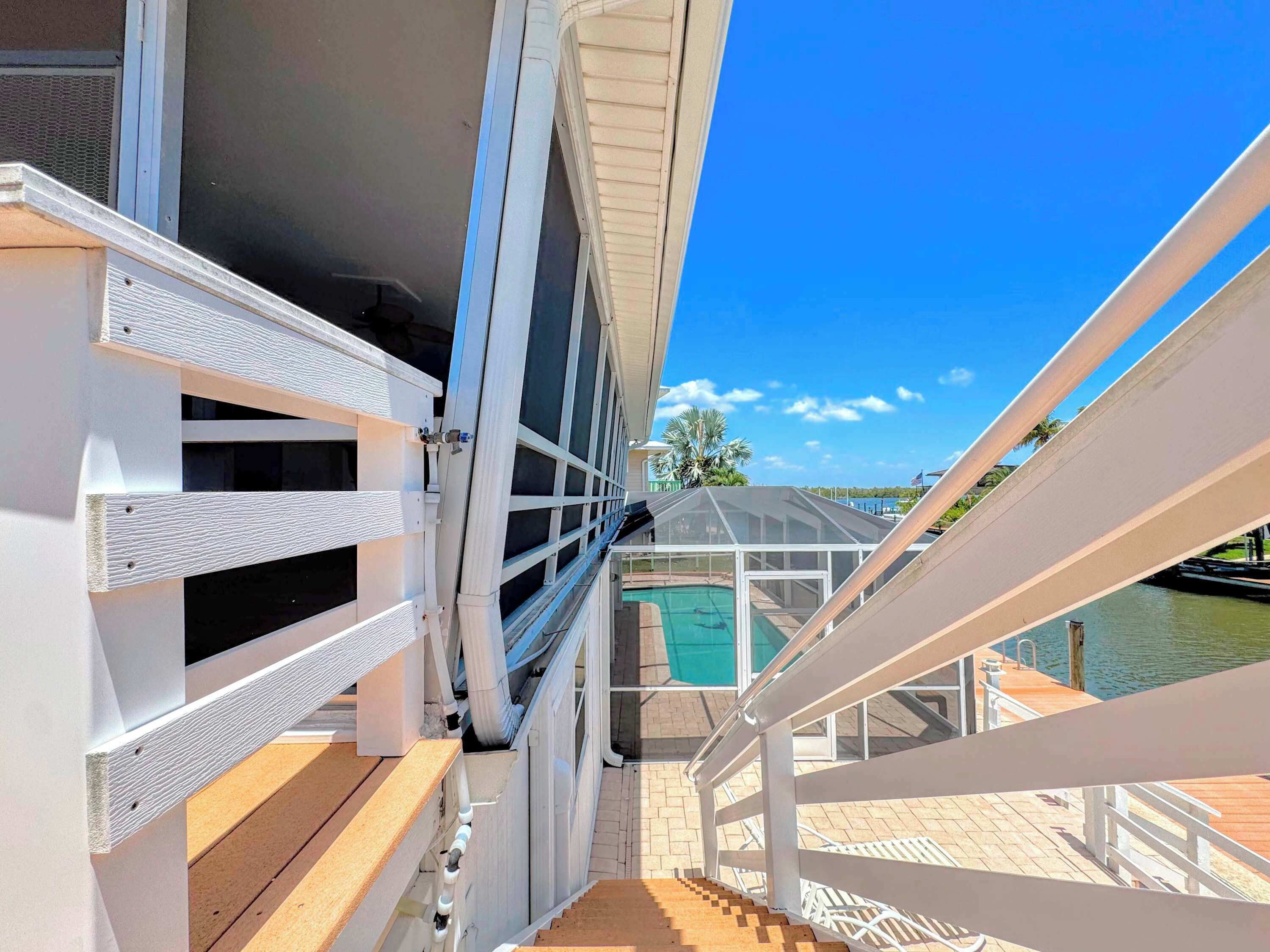 Terraza con vistas a una piscina y cielo despejado.