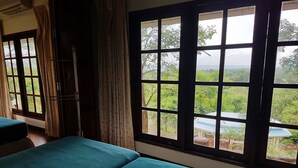 A room with two beds, a window with a view of greenery, and a curtain. - Rai Fhun Pen Jing Resort (Sung Noen)