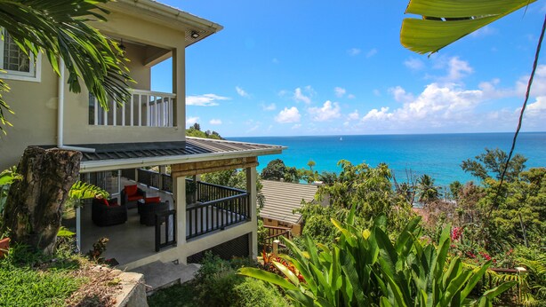 A two-story house with a balcony overlooking a beach. - Kaz Bulinger (Mahé Island)