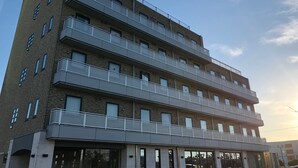 A multi-story building with balconies and large windows. - Business Hotel Cosmo Inn (Fukuroi)