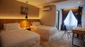 A hotel room with two beds, a wooden headboard, a hanging light, an air conditioning unit, a window with curtains, and a small table with a chair. - The Marion Hotel (Johor Bahru)