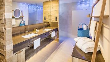 A modern bathroom with a wooden vanity, dual sinks, a large mirror, and a glass shower enclosure.