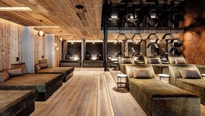 Un spa moderne doté de planchers en bois, de nombreux espaces de détente et de motifs géométriques sur les murs.