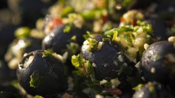 A close-up of olives with a green herb and garlic mixture.