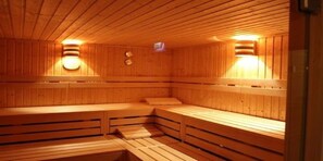 Una sauna de madera con bancos y luces en la pared.