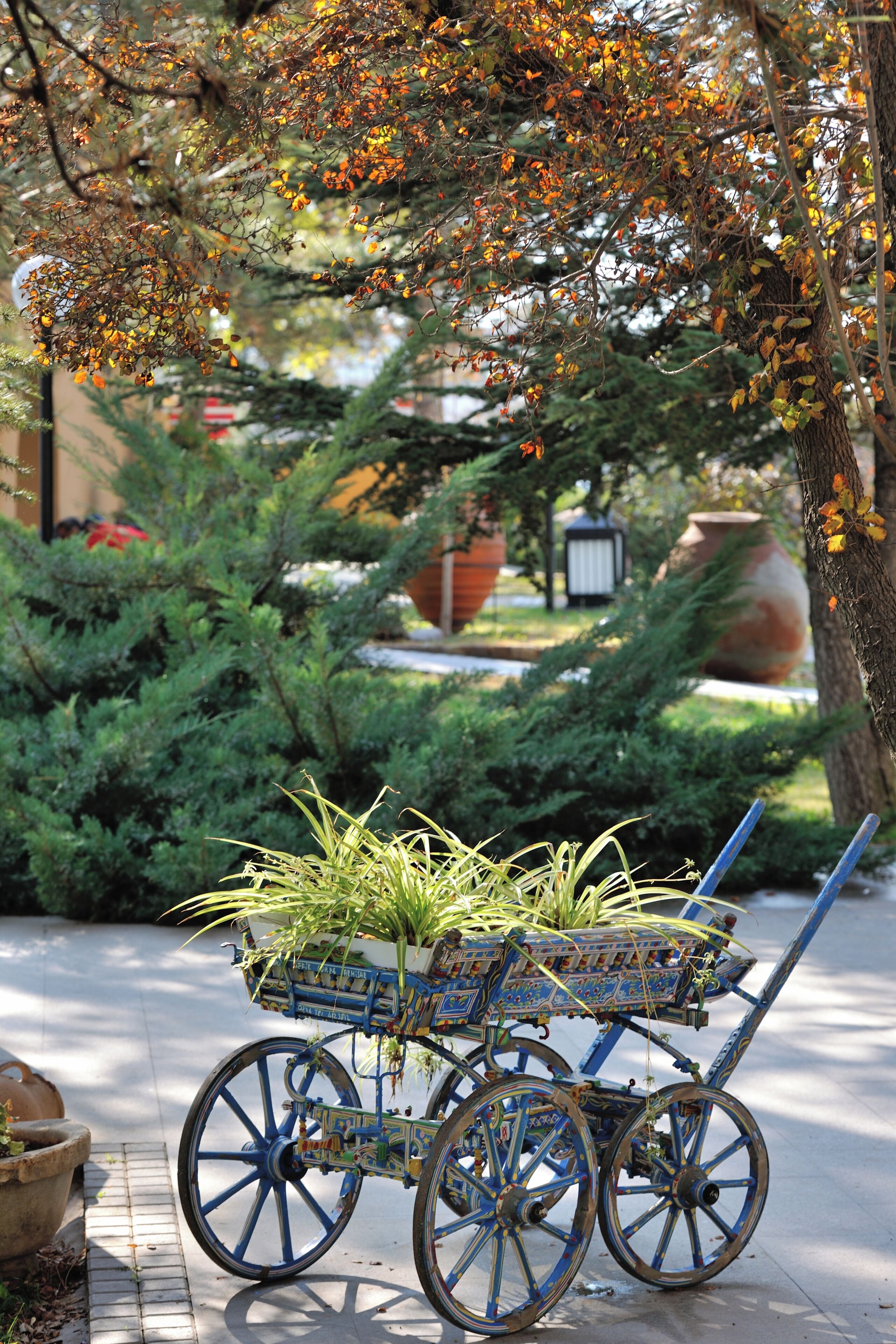 Un chariot muni d’un panier pour plantes, de roues et d’une poignée.
