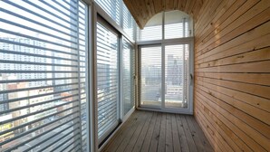 A room with large windows, wooden walls, and a sloped ceiling. - Central Tourist Hotel (Anyang)