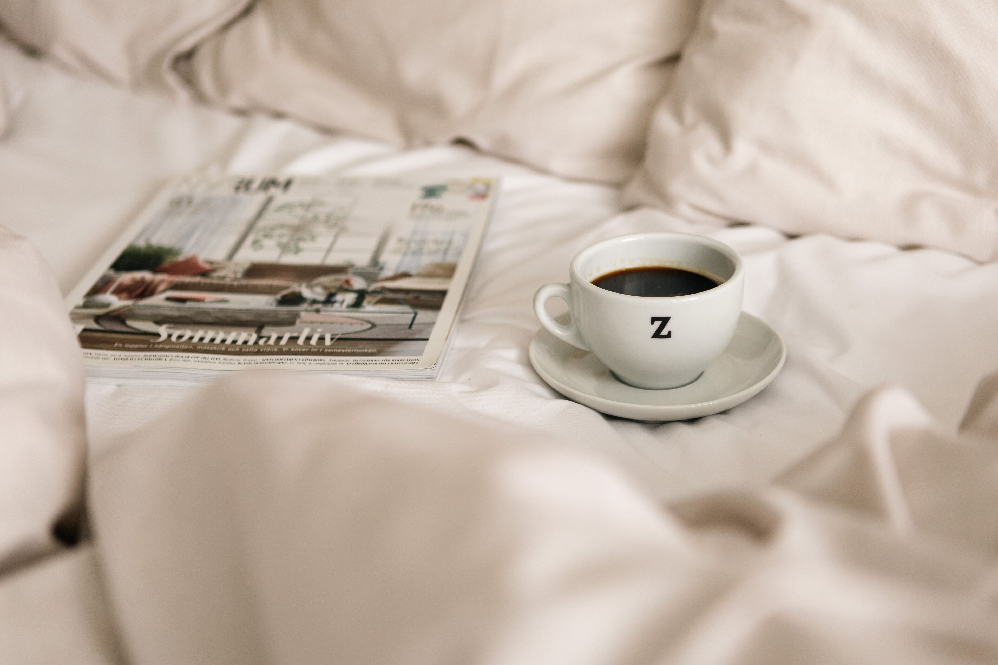 Un lit, une tasse de café et un magazine.