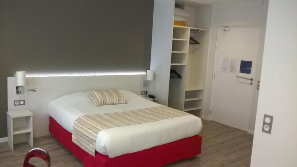 A bedroom with a bed, bedside tables, a wardrobe, and a door.