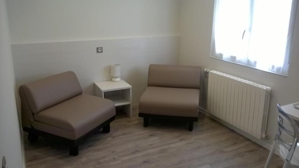 A room with two sofas, a small table, and a radiator.