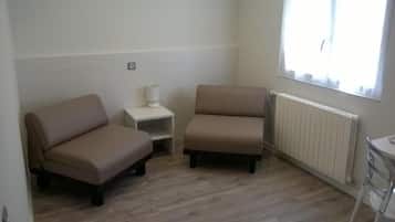 A room with two sofas, a small table, and a radiator.